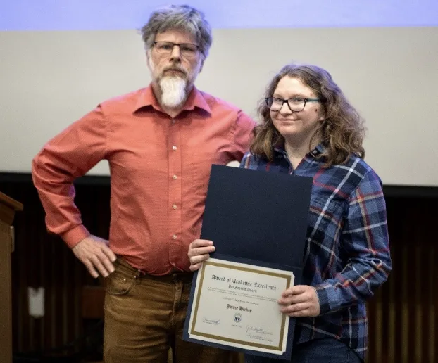 Doug Lynch standing with Jaime Hickey holding her award.