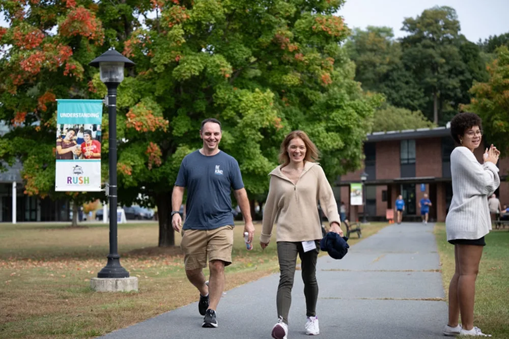 Smiling parents walking across the quad.