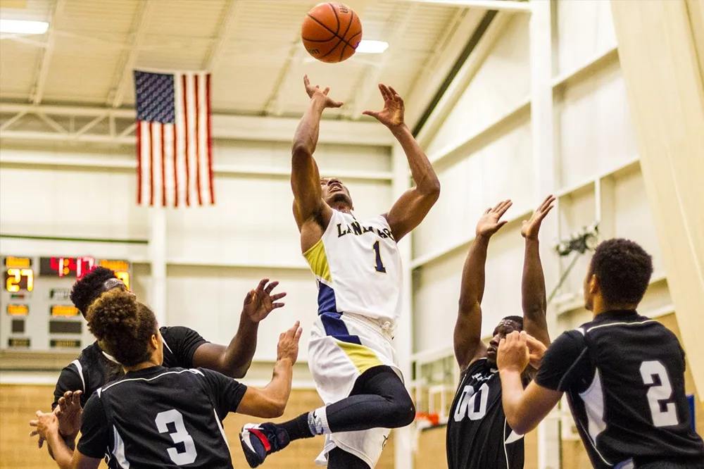 A Landmark College men's basketball player dunking the ball.