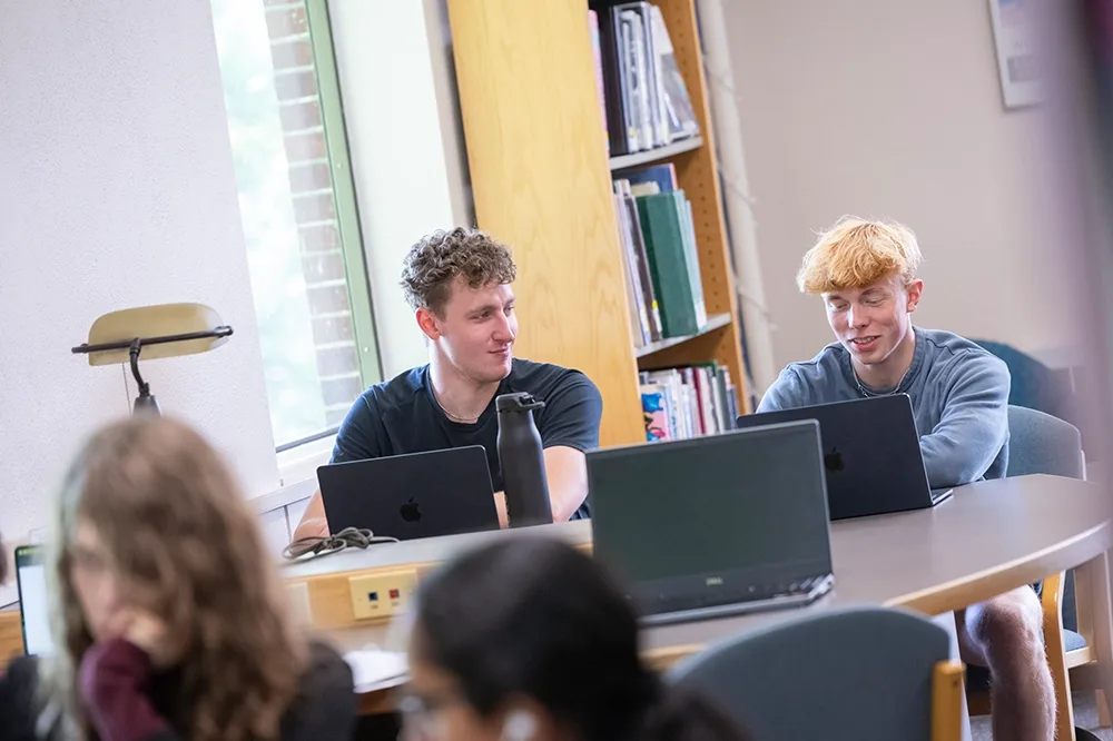 Two male students having a discussion in class.