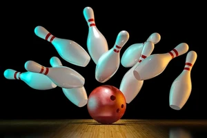 Bowling pins being hit by a rust-colored bowling ball.