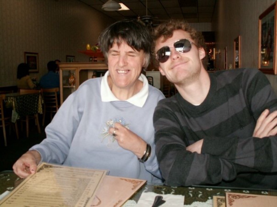 Two people smiling at a restaurant table with menus in front of them.