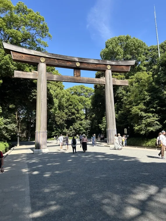 a crowd of people walking towards and away from a Torii gate.