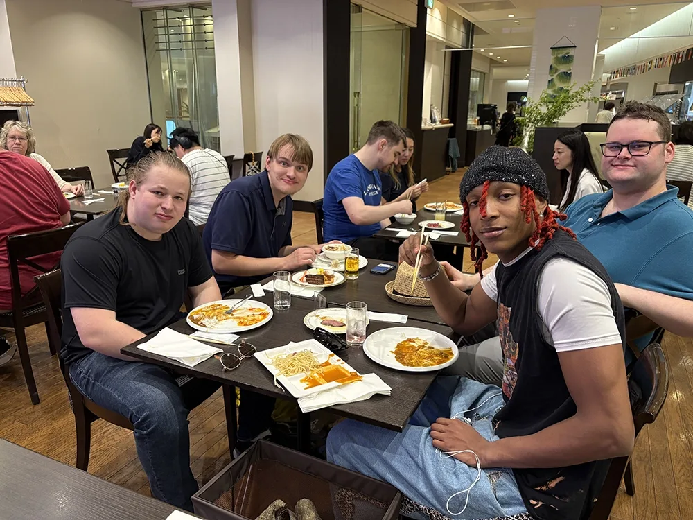 People dining in a casual restaurant. Others eat and chat at nearby.