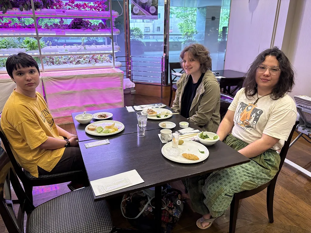 People dining in a casual restaurant. Others eat and chat at nearby.