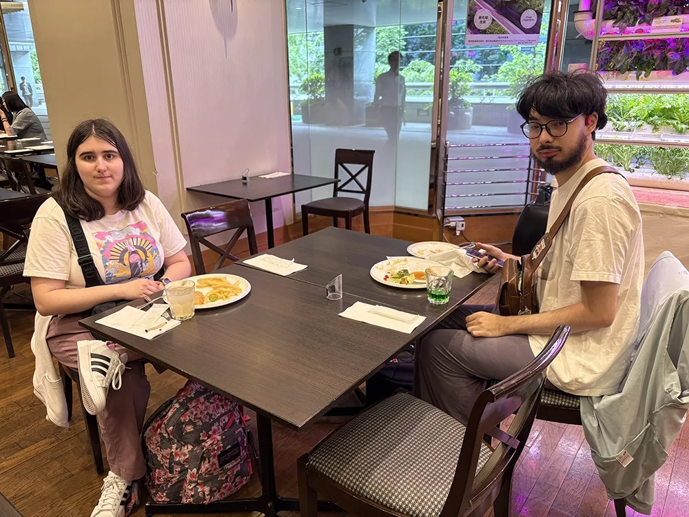 People dining in a casual restaurant. Others eat and chat at nearby.