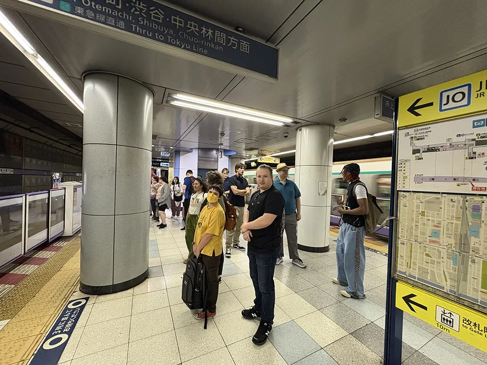 A group of people standing and waiting for a subway.