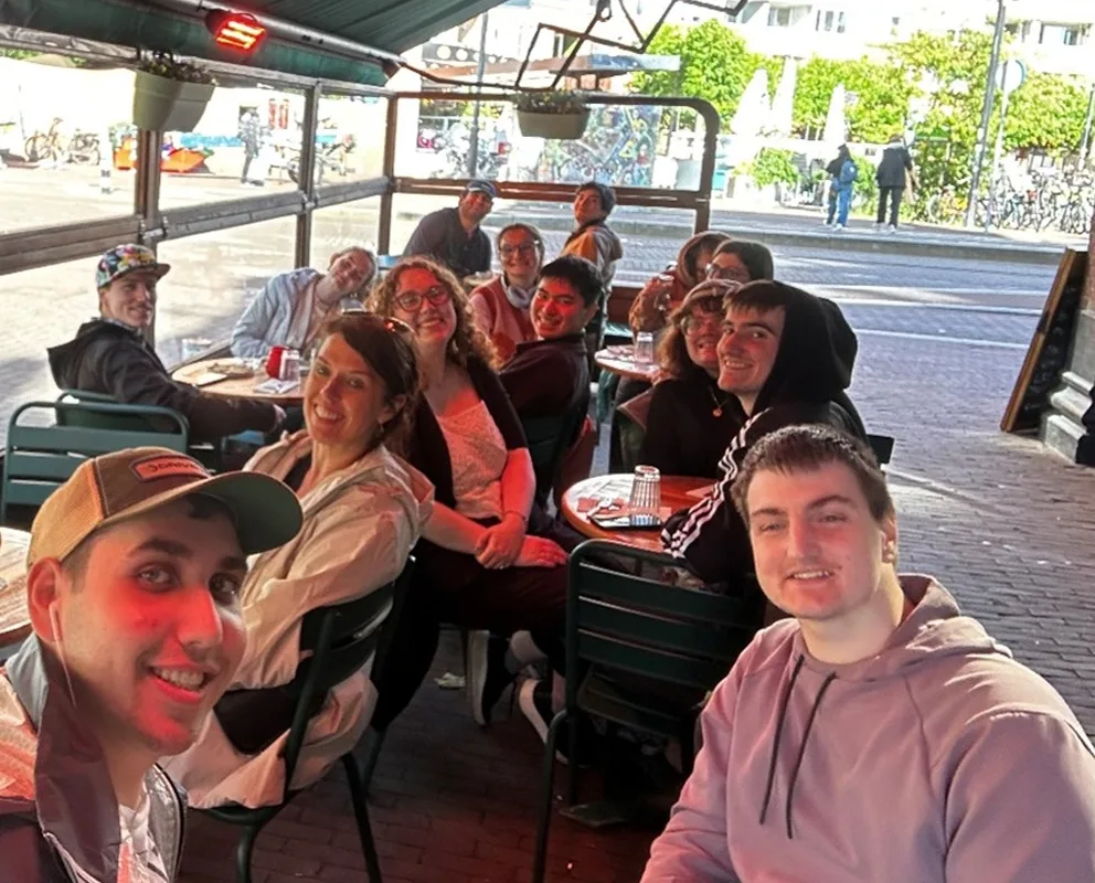 Group of students around tables under an awning