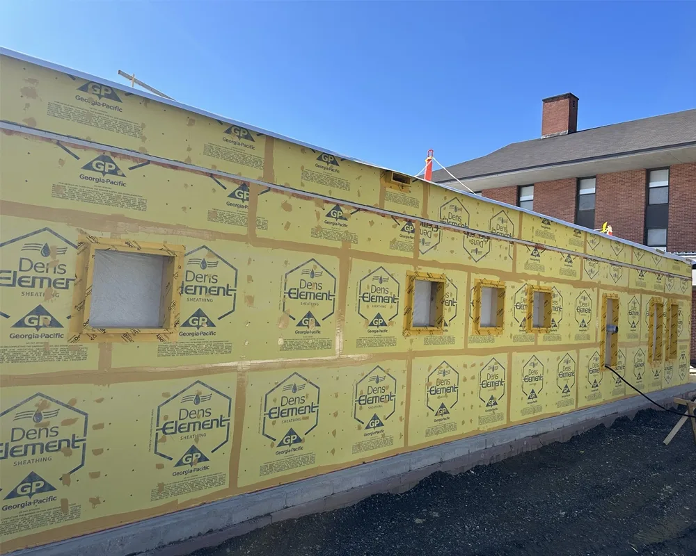 building exterior with window cutouts and yellow sheathing