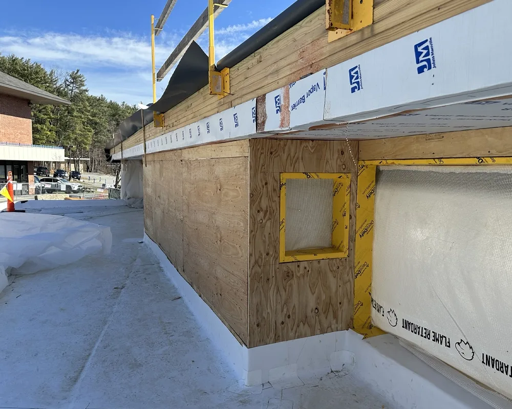 Side view of exterior with window frames and plywood