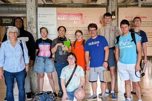 Group of students and faculty posing in front of sign at Mass MOCA