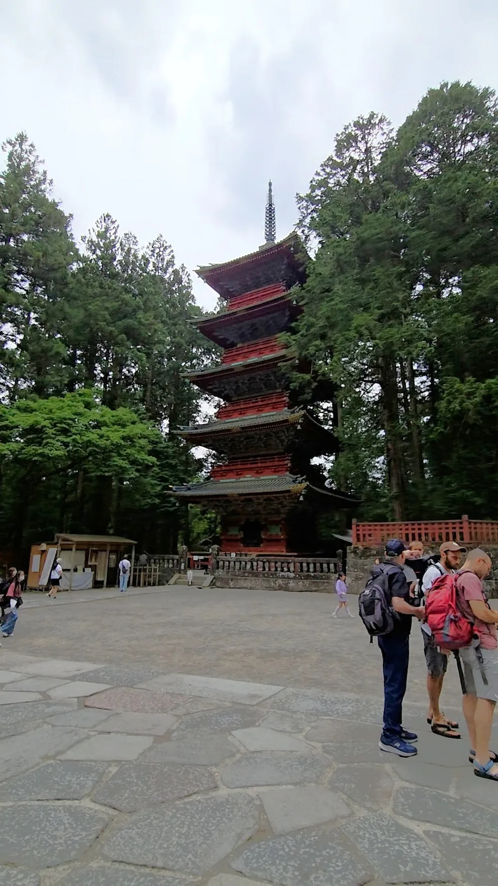 A group of people standing in front of a tall pagoda.