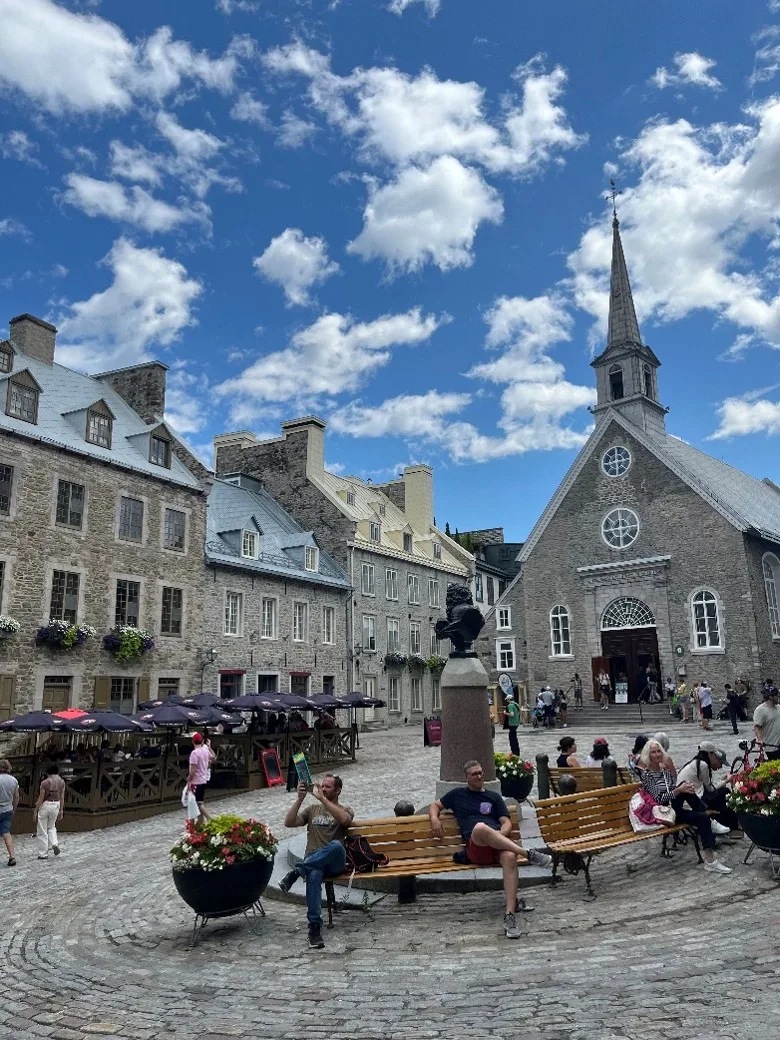 a church and other buildings with a cobblestone street in the foreground