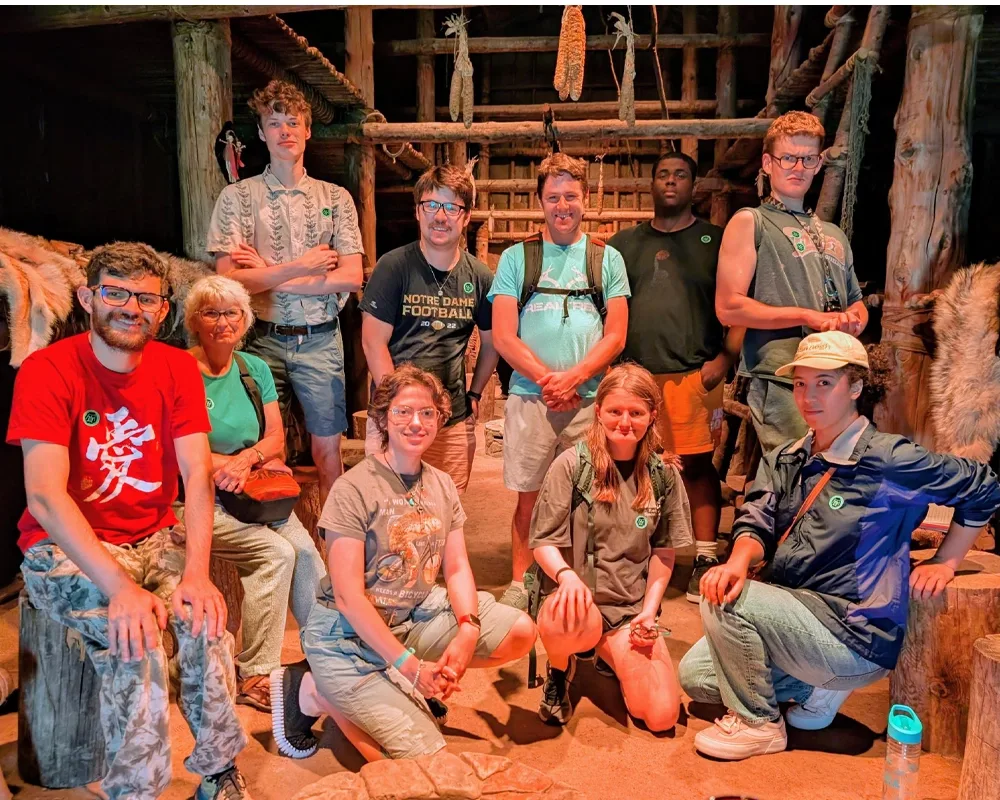 a group of students and their teacher inside an indigenous long house