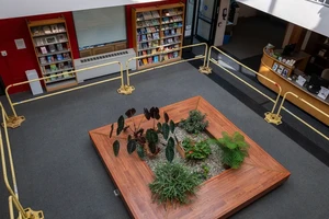 Overhead view of seating area below skylight on the main floor of the library. Metal railings have been placed around it for safety purposes