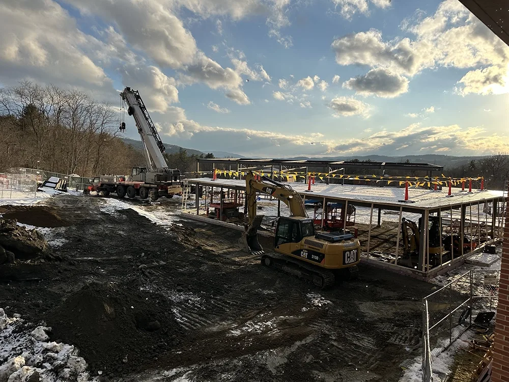 excavator digging through dirt at construction site