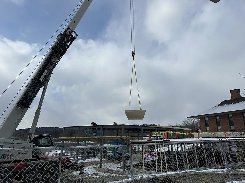 crane lowering a panel on to roof of structure
