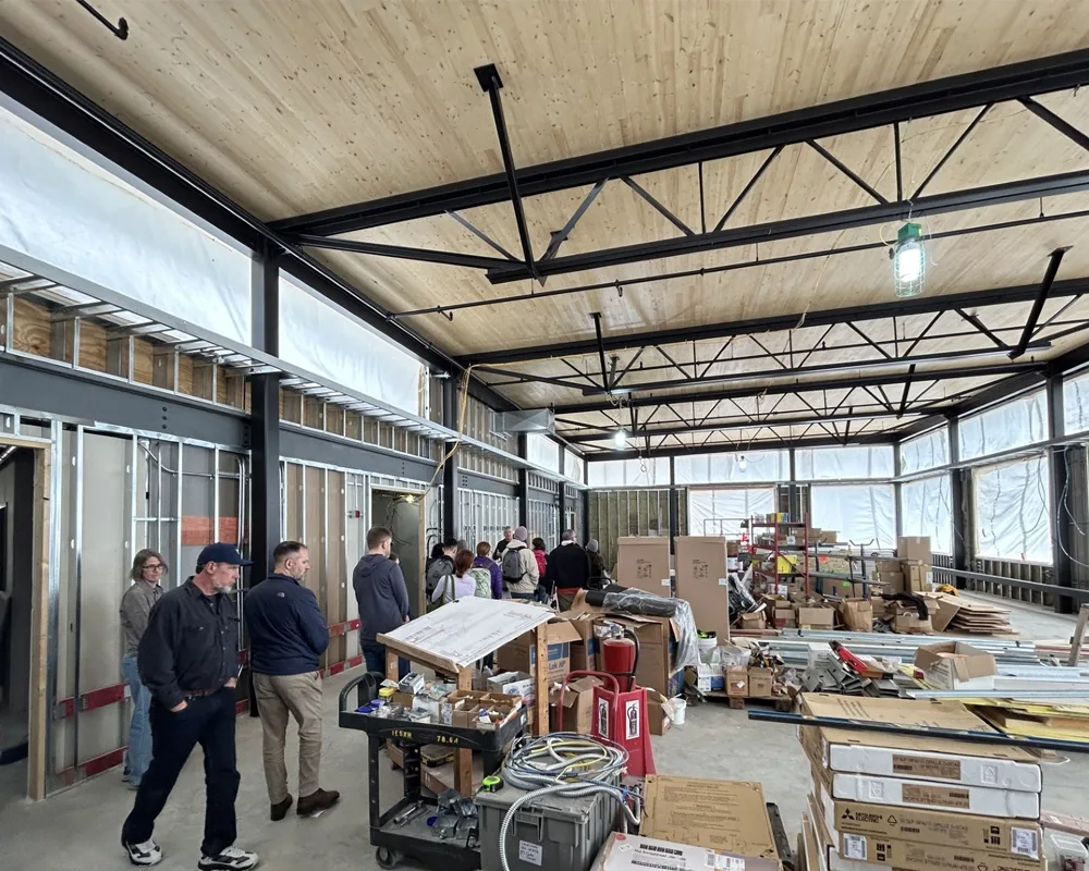 A group of people moving around a large open space of a building under construction