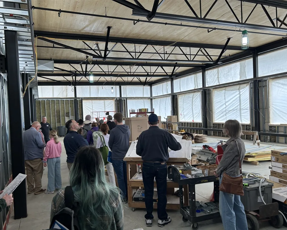 A group of people looking around a large open space of a building under construction