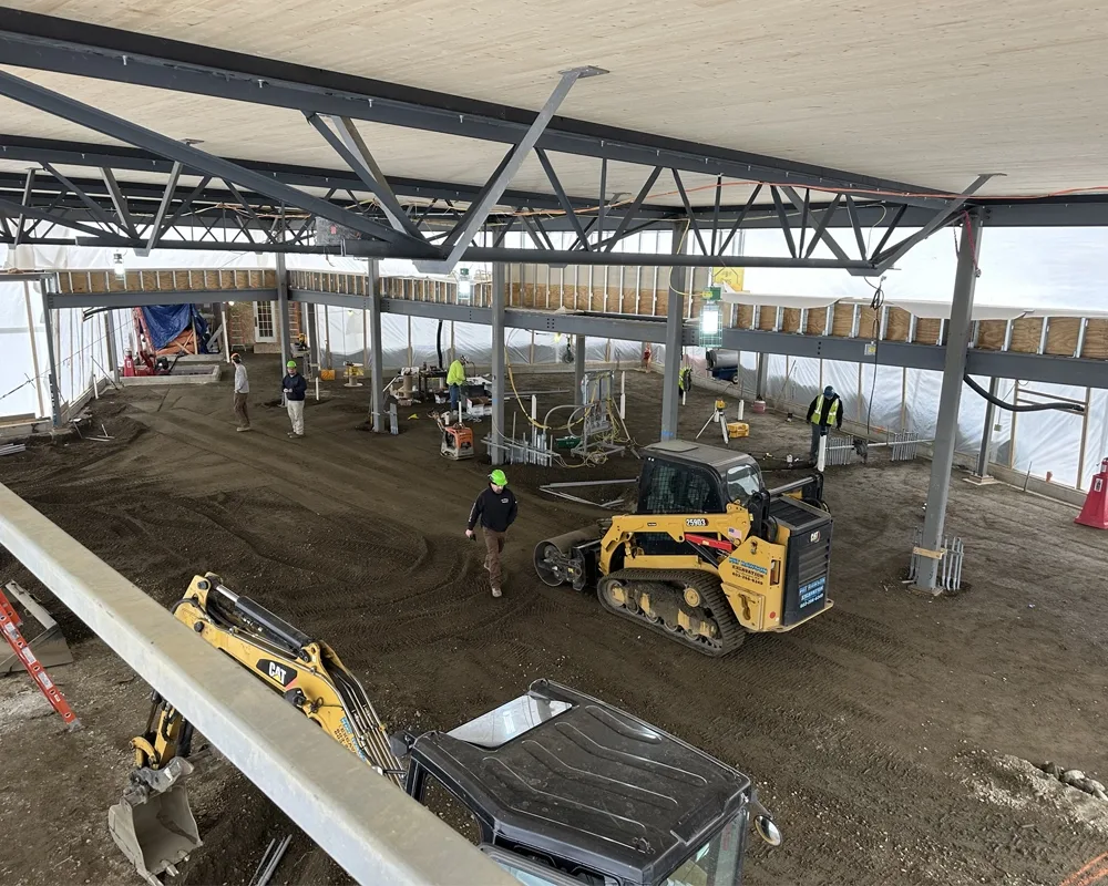 overhead view of construction space with a machine roller smoothing out the dirt