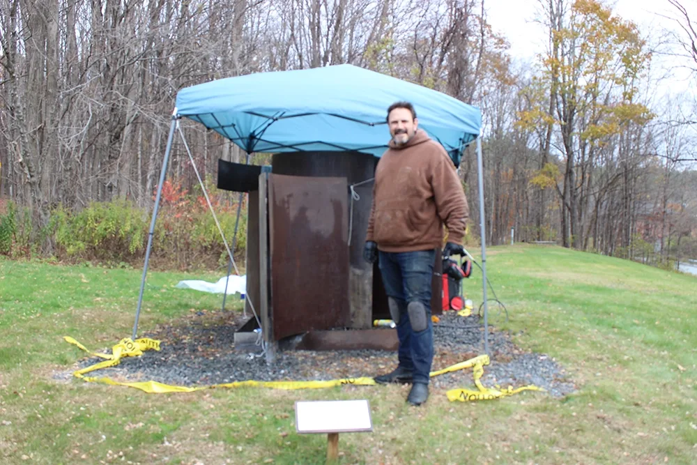 Rodrigo Nava standing in front of the sculpture on Route 5.