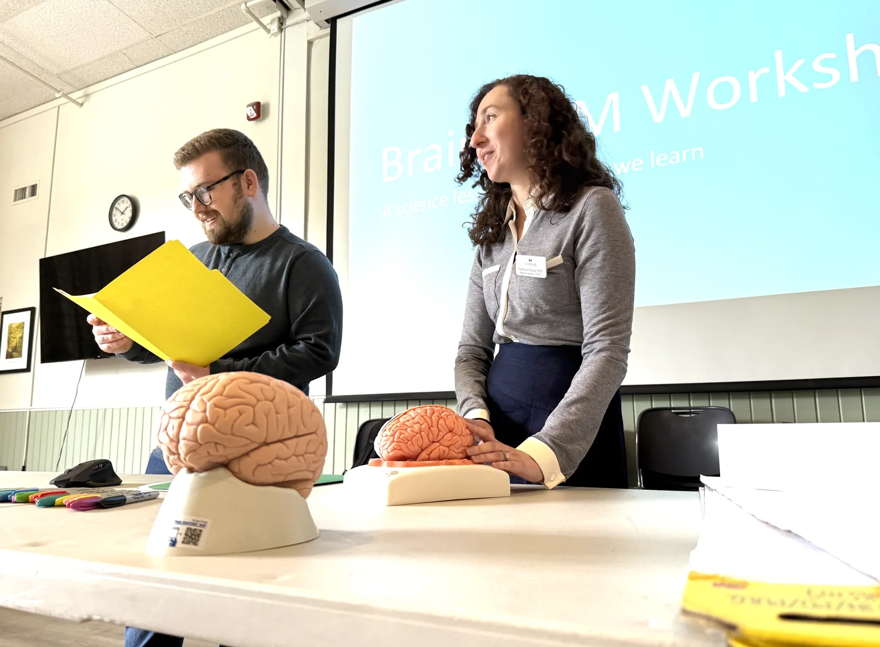 Two people presenting in front of a classroom.