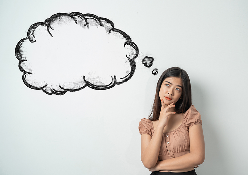 Young woman holding her chin in her hand with a schematic thought bubble to her left.