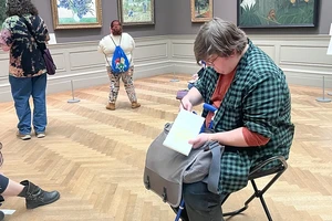 Student sketching while seated in museum gallery