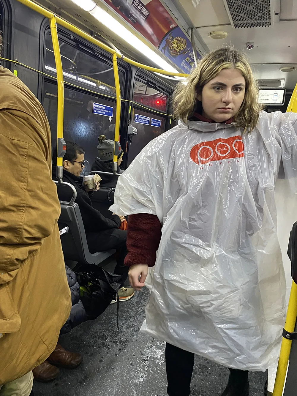 student in a plastic hotel rain poncho on the bus
