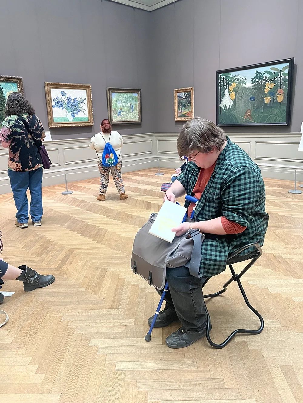 Person sketching while seated in museum spaces