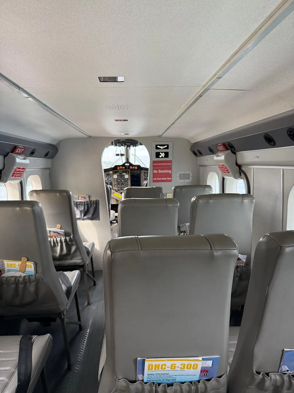 Rows of seats inside an airplane with cockpit visible