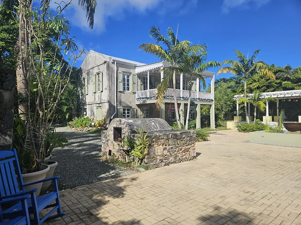 courtyard with palm trees and two story building with large balcony
