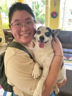 Student holding small dog