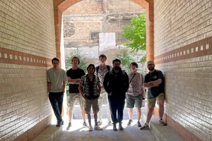 a group of students standing in an arched entrance to a courtyard