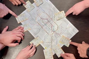 hands holding subway passes on to of a map of Berlin subway system.