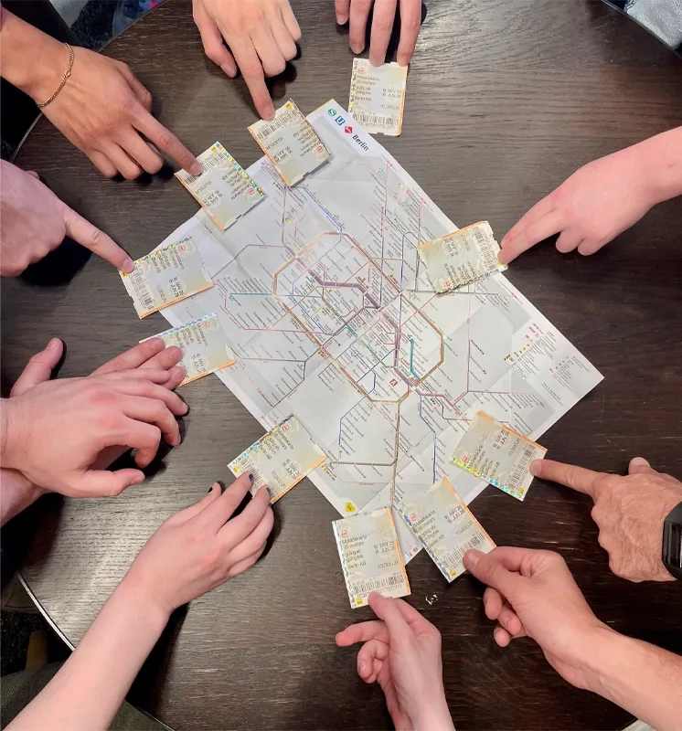 hands holding subway passes on to of a map of Berlin subway system.