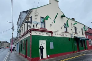 A picture of the Crane Bar from the outside, flags flying from the second story.