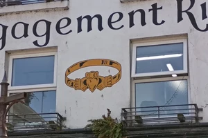 A claddagh ring painted between two windows on a building in Galway over a jewellers