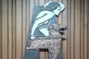 Abbey Theatre logo on wall, which is a profile of a man holding a bow and a dog by his side