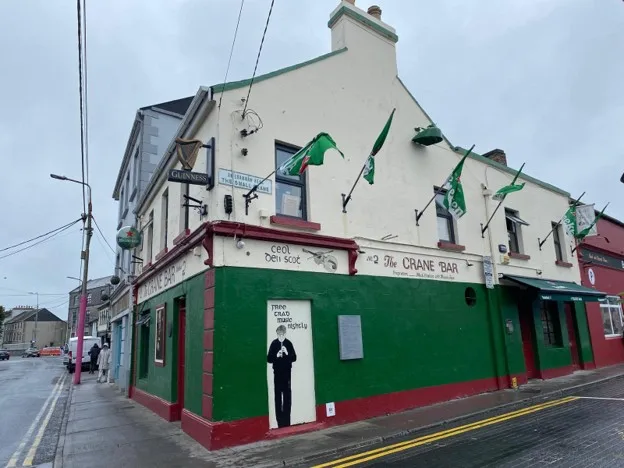 A picture of the Crane Bar from the outside, flags flying from the second story.