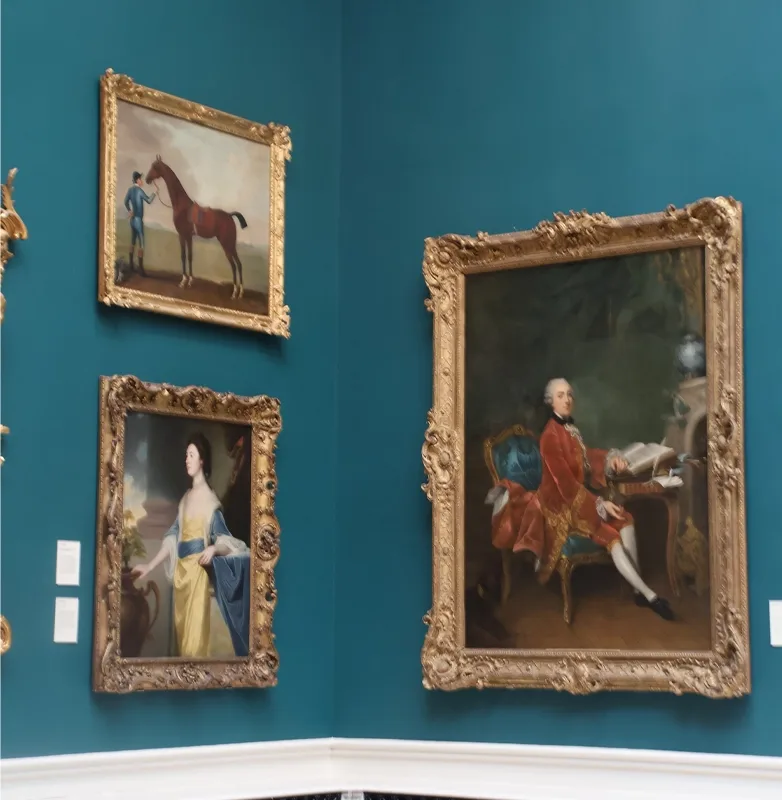 3 portraits in ornate guilded frames, the first of an 18th century woman, the second of a man and his horse and the third of an 18th century man, sitting at a desk in front of an open book