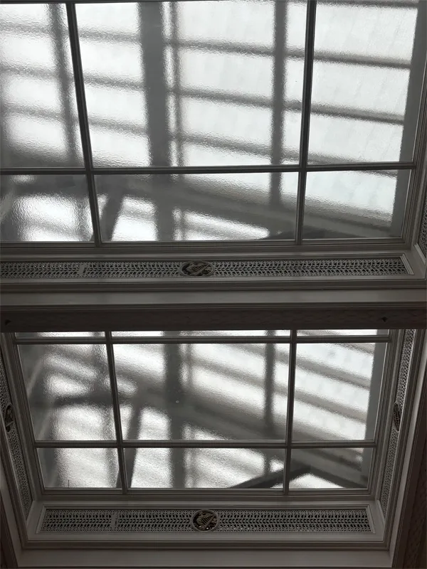 Roof window framed by rectangular decorative shapes with a circle cut into the center of each.