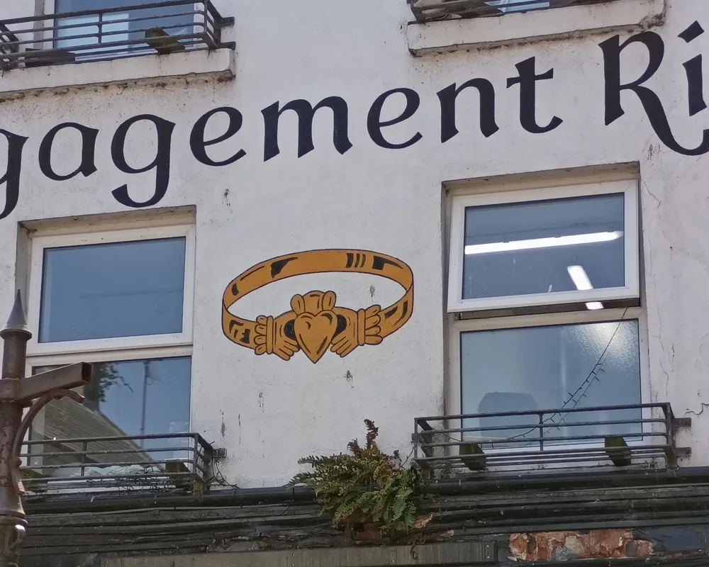 A claddagh ring painted between two windows on a building in Galway over a jewellers