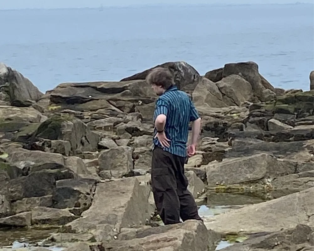 Danny on the rocks and looking at the tidepools at Sandycove