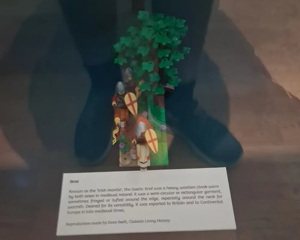 Lego figures dressed in medieval garb holding shields under a thatch of green leaves