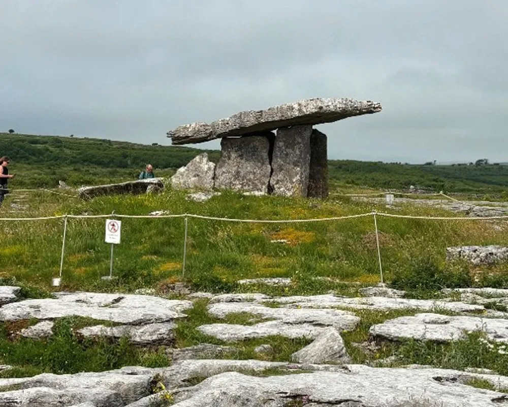 A view of Poulnabrone Dolmen on a grassy ridge surrounded by stone