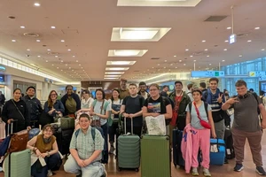 A group of students and their luggage at an airport.