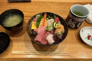 A Japanese meal consisting of sushi, soup, and tea.