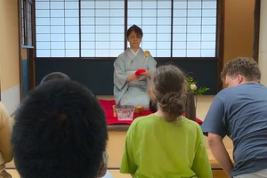 A woman in a kimono leads a Japanese tea ceremony.