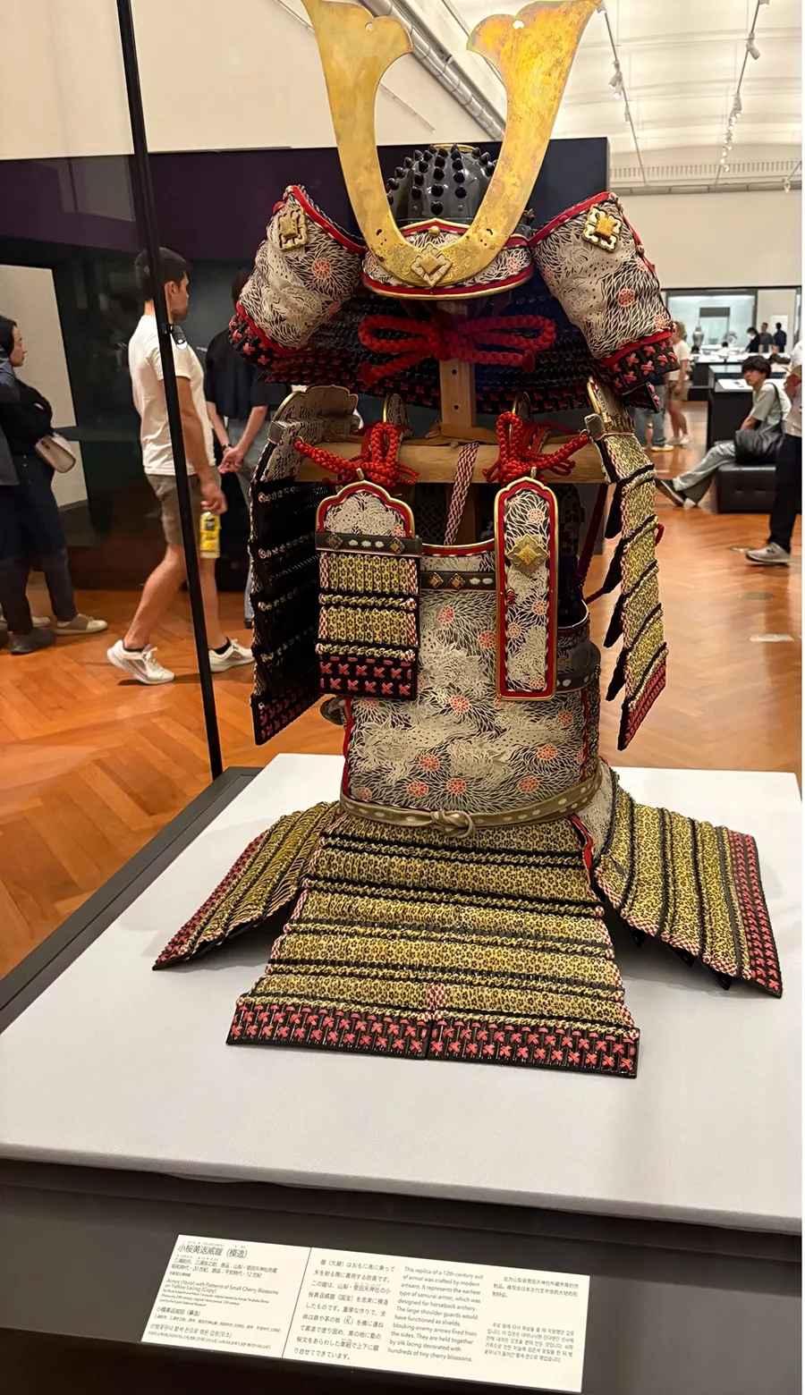 A replica of an ancient samurai helmet in a glass case at a museum.